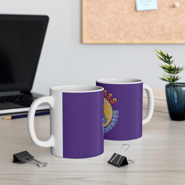 Two mugs sitting on a desk next to a laptop.