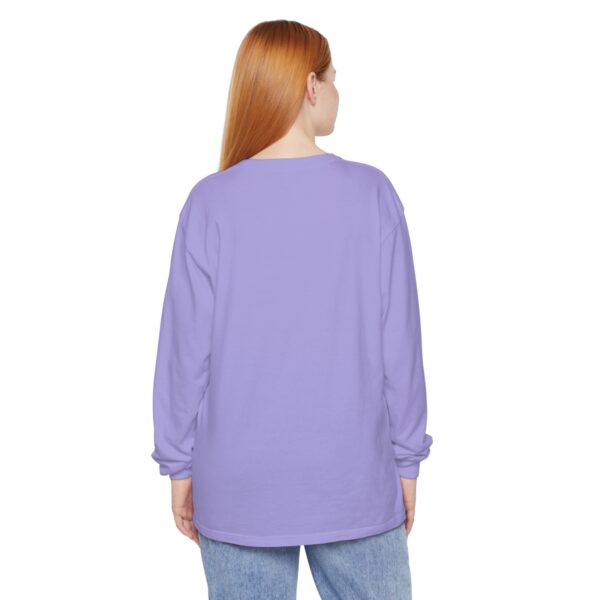 A woman with red hair wearing jeans and purple shirt.